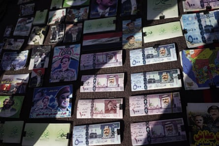 Play money (in Saudi riyals) and other war-related imagery at a market in Sana’a in June 2016.