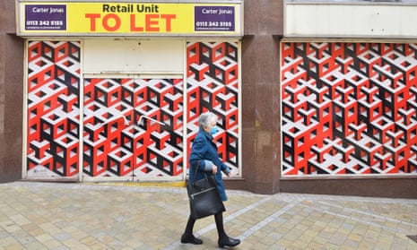 A woman passes an empty shop with a ‘to let’ sign