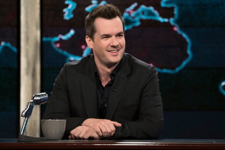 a comedian sitting on a late-night television set