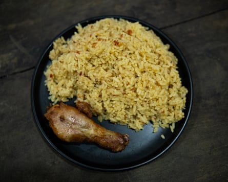 A plate of yellow rice with a chicken drumstick