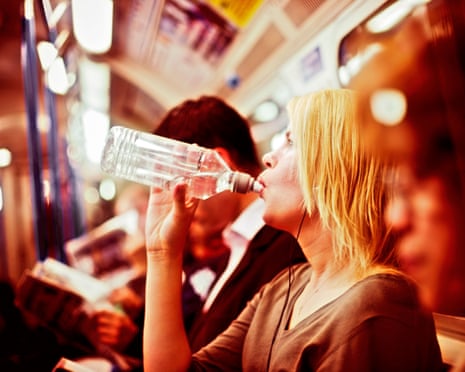 Woman on tube train takes a drink of water during sweltering conditions