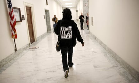 A woman with a Flint Lives Matter sweater walks to a hearing on the crisis