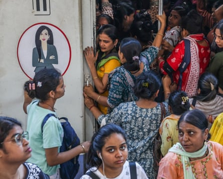 Indian women commuters board a women-only train carriage.
