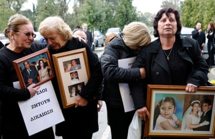 Victims’ relatives hold pictures of their loved ones outside court, in February 2009.