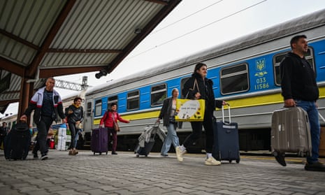 Ukrainians carry their bags as they get off a train from Zaporizhzhia at Przemysl train station in Przemysl, Poland.