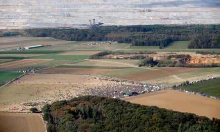 Protesters against the destruction of the forest with the current open cast mine in the background.