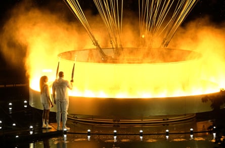 Marie-José Pérec (left) and Teddy Riner light the Olympic cauldron during the opening ceremony