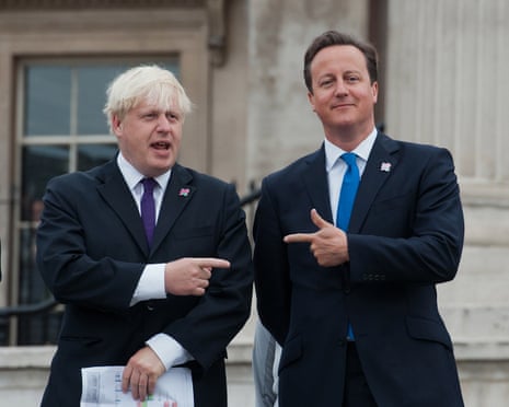 David Cameron and Boris Johnson in dark suits point at each other while standing outside a building