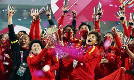 China’s Wang Shuang and Wang Shanshan hold the Women’s Asian Cup trophy and celebrate with team members.