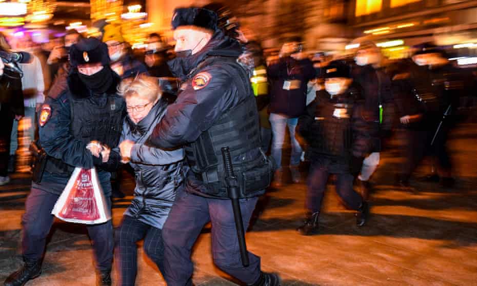 Police officers detain a demonstrator