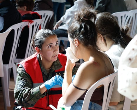 A medic talks to an injured woman at a makeshift camp after a train accident