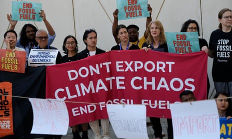 Activists hold a banner reading 'Don't export climate chaos - end fossil fuels'
