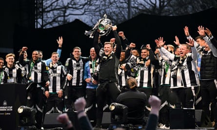 Eddie Howe lifts the Carabao Cup on stage at the Town Moor in Newcastle after the bus parade