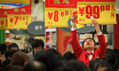 A worker puts up a promotion in a Chinese supermarket.
