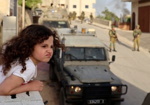 Aqraba, West BankA Palestinian girl watches from the balcony of her house as Israeli soldiers conduct a security operation in the village east of Nablus.