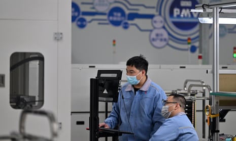 Two men wearing face masks in a lab