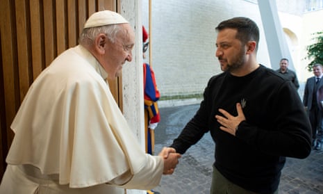 Volodymyr Zelenskiy with his hand on his heart shakes hands with Pope Francis as he arrives at the Vatican.