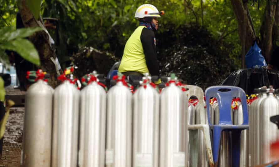 A Thai rescuer prepares oxygen tanks for diving after 12 boys and their football coach were found alive.