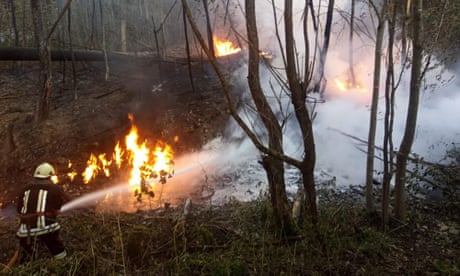 A rescuer fights a fire at an oil pipeline near the village of Strymba, in western Ukraine’s Ivano-Frankivsk region