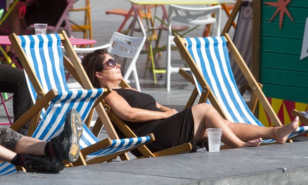 A woman sunbathes on a deckchair in London