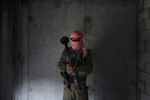 An Israeli soldier dresses as a Palestinian militant