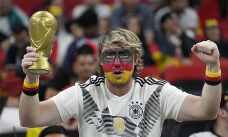 A German soccer fan holds a replica of the Cup and waits for the start of the World Cup group E soccer match between Spain and Germany, at the Al Bayt Stadium