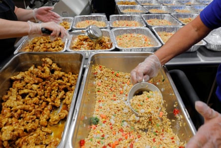 Workers prepare institutional-sized portions of fried rice.
