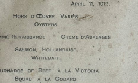Close-up of a waterstained card with printing on it, including items such as creme d'asperges, salmon hollandaise, whitebait, tournedos of beef