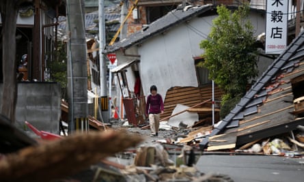 A man walks past collapsed houses on 20 April in Mashiki near Kumamoto, Japan