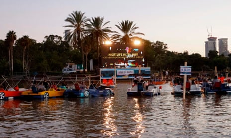 Israelis watch Paddington 2 while sitting in distanced pedal boats.