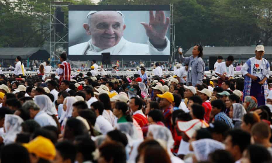 Catholic faithful watch a video of Pope Francis during a mass at Kyite Ka San football stadium in Yangon.