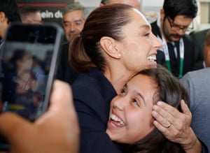 Claudia Sheinbaum embraces an excited-looking young woman