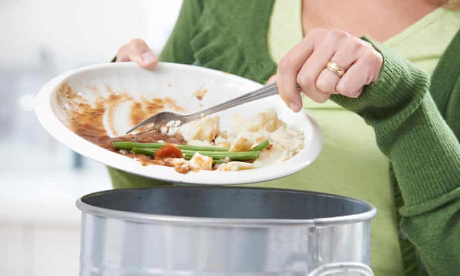 Woman scraping leftover food into bin