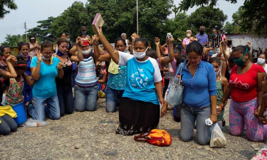 Relatives of inmates pray outside Los Llanos penitentiary after a riot left dozens of dead amid the coronavirus outbreak in Guanare, Venezuela, on 2 May.