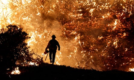 A firefighter works as the Caldor Fire burns in Grizzly Flats, California, in 2021.