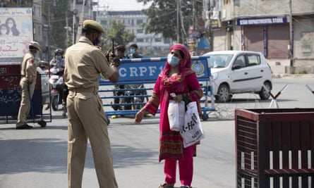 A Kashmiri woman asks a police officer to let her cross a street. ‘What India has done in Kashmir over the last 30 years is unforgivable,’ writes Roy.