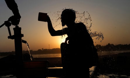 A Pakistani youth cools off under a hand pump in Lahore, Pakistan.