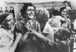 A Turkish woman cries and is consoled by friends