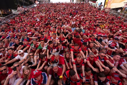 Norway supporters gather to perform their rowing celebration on the iconic red steps in Times Square.