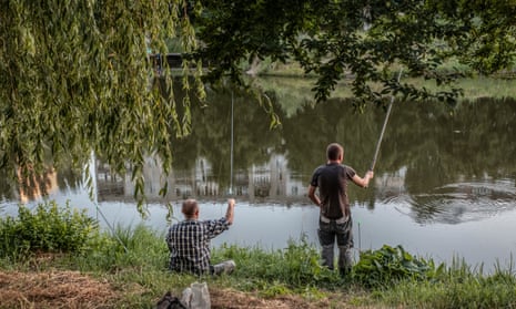 People fishing in a lake in Borodyanka, Ukraine, July 2022