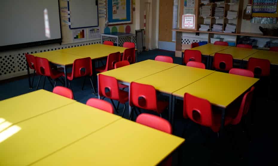 Red chairs and yellow tables in an empty classroom.