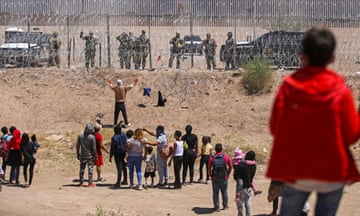 People seeking to enter the US through a barbed wire fence installed along the Rio Grande are driven away with pepper spray shots by Texas National Guard agents.