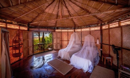 Two beds inside a thatched cabana.