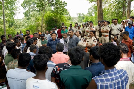 Indian civilians in a confrontation with uniformed police and officials in a forest clearing