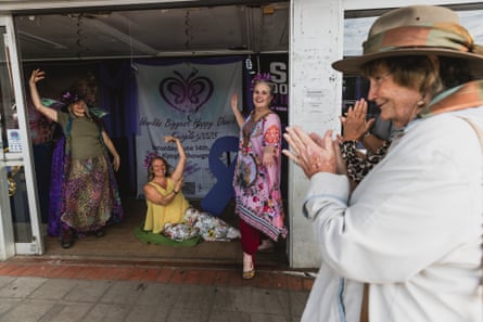 Three dancers from the happy dance committee receive applause from a female passerby on the main street in Kyogle, NSW.