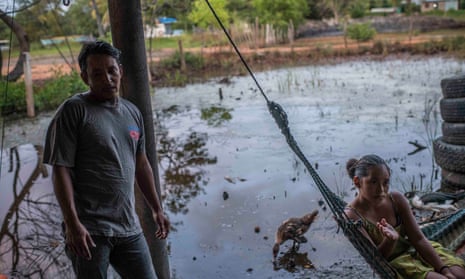 Winter Amaya, 37, with his wife Luisa Mendoza, 31, in the makeshift home they share with their three children, after their home in another part of Chapagua was swept away by the River Aguán during Hurricane Eta.