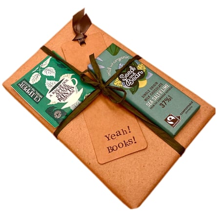 A gift-wrapped book with a chocolate bar and one sachet containing a teabag.