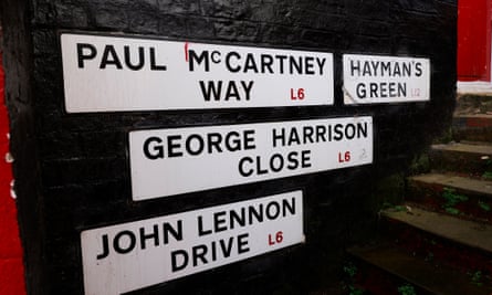 Signs on an outside wall that say 'Paul McCartney Way', 'Hayman's Green', 'George Harrison Close' and 'John Lennon Drive'