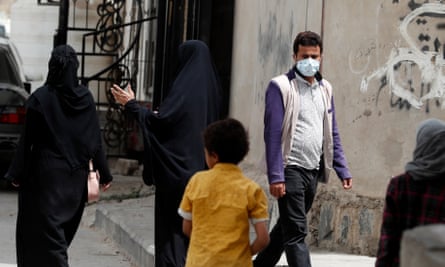 A Yemeni man wearing a protective face mask walks through a neighborhood in Sana'a, Yemen