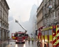 Firefighters work to put out the remains of the fire at Glasgow Central station
